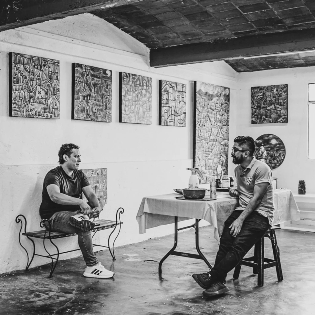 Conversación con artista en taller con obra gráfica expuesta en Oaxaca.