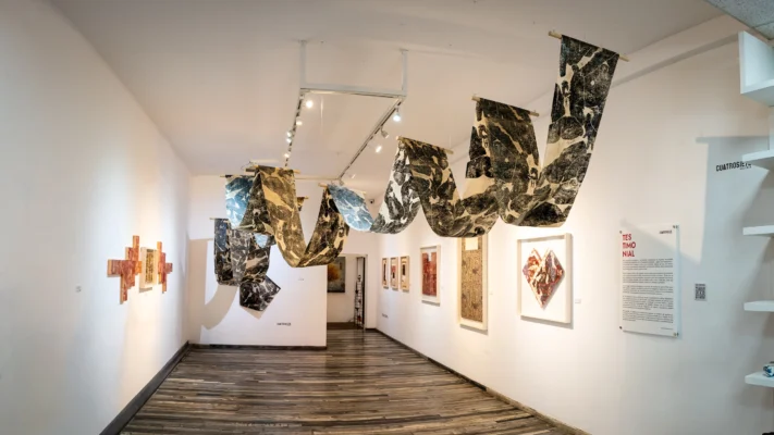 Vista del pasillo con instalación y obra gráfica en la exposición Testimonial en CuatroSie7e Galería Pasillo Gráfico con la exposición Testimonial con instalación suspendida y obra gráfica en CuatroSie7e Galería