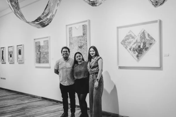 Olga Sánchez Cabrera, Julio Martínez y Elizabeth Nepomucena durante exposición en CuatroSie7e Galería Olga Sánchez Cabrera, Julio Martínez y Elizabeth Nepomucena posando en sala de exposición en CuatroSie7e Galería